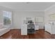 Well-lit home office with hardwood floors, built-in shelves, a modern desk, and a comfortable chair at 1911 Firenza Dr, Apex, NC 27502