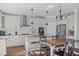 Open kitchen boasts stainless appliances, granite counters, breakfast bar, and hardwood flooring at 1911 Firenza Dr, Apex, NC 27502