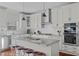 Modern kitchen island features granite countertops, stainless appliances, and wooden bar stools at 1911 Firenza Dr, Apex, NC 27502