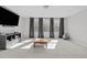 Spacious living room with large windows, plush carpet, and modern furniture at 1911 Firenza Dr, Apex, NC 27502