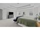 Bright main bedroom featuring a tray ceiling, plush carpet, and neutral color scheme at 1911 Firenza Dr, Apex, NC 27502