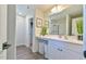 Well-lit bathroom with wood-style floors, double vanity, and a view into the walk-in closet at 2065 Alderman Way, Creedmoor, NC 27522