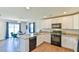 Well-equipped kitchen with black appliances, granite countertops, and view to dining area at 2065 Alderman Way, Creedmoor, NC 27522