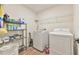 The laundry room features a washer, dryer, storage shelves, and wood-style floors at 2065 Alderman Way, Creedmoor, NC 27522