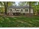 Home boasts a spacious yard with a deck and shade trees at 2108 Canterbury Rd, Clayton, NC 27520
