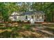 Charming single-story home with a inviting front porch, surrounded by lush greenery and mature trees at 2108 Canterbury Rd, Clayton, NC 27520