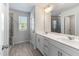 Bright bathroom features a double sink vanity, wood-look floors, and a tiled shower with natural light at 2137 Caen St, Raleigh, NC 27610