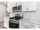 A kitchen with stainless steel appliances, white cabinets and quartz countertops at 2137 Caen St, Raleigh, NC 27610
