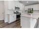 A modern kitchen with white cabinets, stainless steel appliances, and quartz countertops at 2137 Caen St, Raleigh, NC 27610