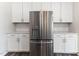 A kitchen with a stainless steel refrigerator and white cabinets at 2137 Caen St, Raleigh, NC 27610