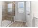 Tiled shower features built-in bench seating and glass doors, complemented by a window with natural light at 2137 Caen St, Raleigh, NC 27610