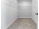 Empty walk-in closet with installed white wire shelving and neutral carpet for easy organization and storage at 2137 Caen St, Raleigh, NC 27610