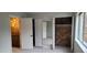 A bedroom features an exposed brick wall, mirrored closet doors, and a window, creating a unique and stylish space at 220 Elizabeth St # A-17, Chapel Hill, NC 27514