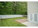 Backyard view with a white fence, green grass, and a brick patio at 228 Adefield Ln, Holly Springs, NC 27540