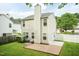 Home backyard with brick patio, lush lawn, white fencing, and mature trees at 228 Adefield Ln, Holly Springs, NC 27540