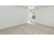 Bedroom with neutral carpet, large window, and fresh white paint at 228 Adefield Ln, Holly Springs, NC 27540