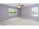 Cozy bedroom with two windows, neutral carpet, and lilac painted walls at 228 Adefield Ln, Holly Springs, NC 27540