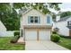 Charming two-story home featuring a two-car garage, stone accents, and manicured landscaping at 228 Adefield Ln, Holly Springs, NC 27540