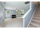 Spacious living room with a cozy fireplace, staircase, and ample natural light from multiple windows at 228 Adefield Ln, Holly Springs, NC 27540