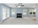 Bright living room with a fireplace, French doors, and plenty of natural light with view to dining area at 228 Adefield Ln, Holly Springs, NC 27540