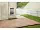 A brick patio flows to concrete, beside a home and a white fence, with grass visible at 228 Adefield Ln, Holly Springs, NC 27540