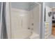 Bathroom with a tub and shower combination, white tile surround, and simple fixtures at 2456 Nealwood Ave, Graham, NC 27253