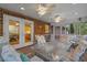 A covered patio with brick columns, ceiling fans, a glass-topped table, and comfortable seating at 2456 Nealwood Ave, Graham, NC 27253