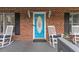 Inviting front porch with a blue door and traditional rocking chairs on a brick facade at 2456 Nealwood Ave, Graham, NC 27253