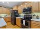 Well-equipped kitchen featuring wooden cabinetry, stainless steel appliances, and functional modern design at 2456 Nealwood Ave, Graham, NC 27253