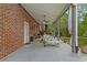 Covered brick patio featuring outdoor seating, ceiling fan, and access to backyard at 2456 Nealwood Ave, Graham, NC 27253
