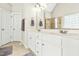 Bathroom features a double vanity, a large mirror, white cabinets, tiled floors and access to a shower and toilet at 249 Mill Creek Dr, Clayton, NC 27527