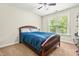 Carpeted bedroom featuring a wood bedframe, ceiling fan, and natural light from the large window at 249 Mill Creek Dr, Clayton, NC 27527