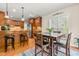 Eat-in kitchen with breakfast table, wooden cabinets and trim, hardwood floors, and a colorful rug at 249 Mill Creek Dr, Clayton, NC 27527