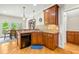 Open-concept kitchen features wood cabinets, dishwasher, hardwood floors, and arched entryway at 249 Mill Creek Dr, Clayton, NC 27527