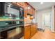 Contemporary kitchen features dark appliances, wood cabinets, stone backsplash, and hardwood flooring at 249 Mill Creek Dr, Clayton, NC 27527