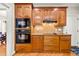 Contemporary kitchen features dark appliances, wood cabinets, stone backsplash, and hardwood flooring at 249 Mill Creek Dr, Clayton, NC 27527