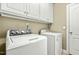 Clean and well lit laundry room with washer, dryer and storage cabinets at 249 Mill Creek Dr, Clayton, NC 27527
