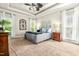 Comfortable bedroom features plush carpeting, tray ceiling, stylish ceiling fan, and natural light through two windows at 249 Mill Creek Dr, Clayton, NC 27527