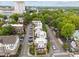 An aerial perspective captures a row of townhomes nestled among lush green trees in a vibrant urban setting at 256 William Drummond Way, Raleigh, NC 27604