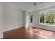 Bright bedroom with hardwood floors, ceiling fan, and a door leading to the balcony at 256 William Drummond Way, Raleigh, NC 27604
