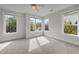 Bright bedroom featuring a ceiling fan, carpeted floors, and plenty of natural light from multiple windows at 256 William Drummond Way, Raleigh, NC 27604