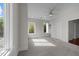 Bright bedroom featuring a ceiling fan, built in shelves, carpeted floors, and plenty of natural light from multiple windows at 256 William Drummond Way, Raleigh, NC 27604
