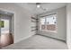 Cozy bedroom with built-in shelving, a large window, and neutral carpeting at 256 William Drummond Way, Raleigh, NC 27604