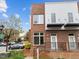 Brick townhome featuring a modern design with clean lines and black accents, complemented by well-maintained landscaping at 256 William Drummond Way, Raleigh, NC 27604