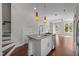 Open concept kitchen featuring a large island with modern pendant lighting and stainless steel appliances at 256 William Drummond Way, Raleigh, NC 27604