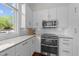 Modern kitchen with white cabinets, stainless steel appliances, and a stylish tile backsplash at 256 William Drummond Way, Raleigh, NC 27604