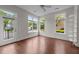 Bright living room with hardwood floors, multiple windows offering neighborhood views, and access to a balcony at 256 William Drummond Way, Raleigh, NC 27604