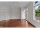 Spacious living room with hardwood floors, a ceiling fan, and multiple windows with neighborhood views at 256 William Drummond Way, Raleigh, NC 27604