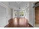 Open-concept living room with hardwood floors, large windows, and access to the balcony at 256 William Drummond Way, Raleigh, NC 27604