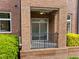 Cozy brick porch with a black railing, offering a relaxing outdoor space with a ceiling fan at 256 William Drummond Way, Raleigh, NC 27604